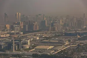 DUBAI, UAE - APRIL 29: Aerial view of Downtown Dubai and skyscrapers during morning sandstorm. Highway and trainline, soft light over the sand