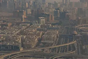 DUBAI, UAE - APRIL 29: Aerial view of Downtown Dubai and skyscrapers during morning sandstorm. Highway and trainline, soft light over the sand