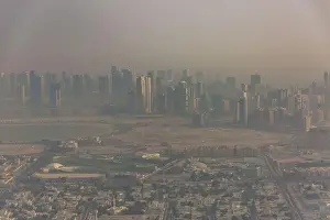 DUBAI, UAE - APRIL 29: Aerial view of Downtown Dubai and skyscrapers during morning sandstorm. Highway and trainline, soft light over the sand
