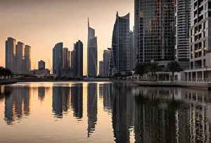 Emirates Prints: Dusk skyline of Jumeirah lakes towers with clear reflections, Dubai, United Arab Emirates