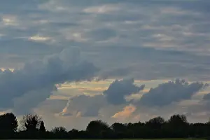 Suffolk Prints: early evening sky with mix of clouds and low light with trees silhouetted on the horizon
