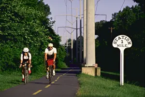 Jogging Prints: Two early morning bicyclists enjoy the W OD Railroad Park biking jogging path in Falls Church Virginia