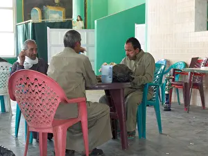 Motel Prints: Egyptian men drinking tea and smoking shesha at remote cafe on roadside in Western desert Egypt