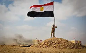 Bilateral Prints: An Egyptian service member places an Egyptian national flag during an Egyptian military demonstration for observers