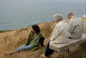 Contemplative Prints: Elderly couple with their daughter sitting and looking out towards the sea