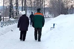 Elderly couple walking in park on autumn day
