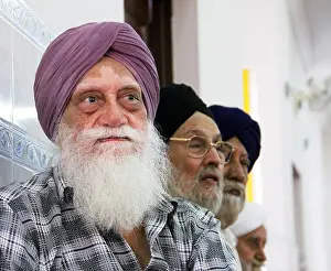 Disorder Prints: An elderly Indian Sikh man with a long white beard wearing a turban with the vitiligo skin disorder at a Sikh Wedding