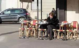Alfresco Prints: elderly Parisian woman sitting outside a cafe in the 6th arrondissement of Paris in winter