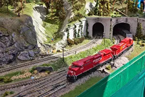 Electric Model Train on miniature train track going through mountain tunnel