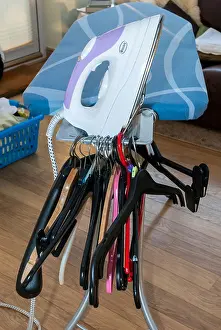 Laundry Prints: An electric steam iron and coat hangers on an ironing board