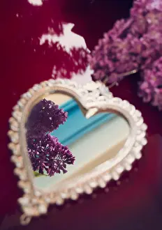 Hear Prints: Elegant heart-shaped mirror with silver frame and lilac flowers on red surface