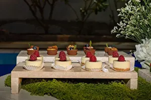 Moss Prints: Elegant mini cheesecakes and chocolate desserts are displayed at a poolside catering buffet event