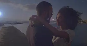 Middle Eastern Prints: Embracing couple standing on concrete pier by ocean at sunset