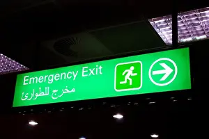 Airport Grounds Prints: Emergency exit sign in an international airport in Middle East with Arabic information