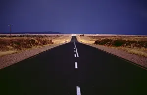 Namibia Prints: endless street never ending infinity tar surface desert road street Africa Namibia dark sky rainy season eerie