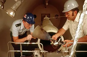 Engineers Prints: Engineers inspect a 50-pound thrust engine after firing it in its chamber at the Rocket Propulsion Lab's satellite
