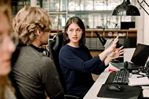 Concentrating Prints: Entrepreneur explaining to colleague while sitting in office