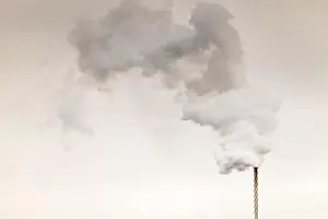 Pollution Prints: Environment pollution problem concept. Smoke from factory chimney on dark cloudy sky