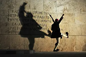 An Evzones soldier in traditional uniform performs an elaborate martial marching routine during the Sunday evening