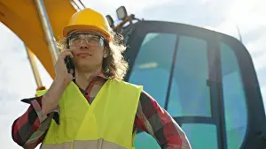 Explaining Prints: Excavator operator in hard hat talking by smartphone