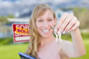 Buyer Prints: Excited Woman Holding House Keys and Sold Real Estate Sign in Front of Nice New Home