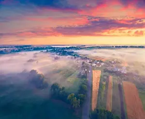 Exciting summer dawn on Ukrainian countryside with foggy fields
