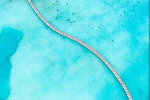 Images Dated 12th August 2019: Exotic aerial view of turquoise water with wooden jetty in Maldives islands. Amazing sea lagoon