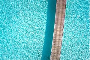 Images Dated 5th August 2019: Exotic aerial view of turquoise water with wooden jetty in Maldives islands. Amazing sea lagoon