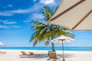 Exotic tropical beach landscape, chairs umbrella with palm tree. Tranquil beach scene for travel inspirational, Summer holiday and vacation concept