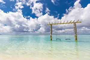 Exotic tropical paradise swings over crystal clear turquoise blue ocean sea water landscape seascape. Luxury summer travel, moody beach view