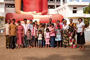 Familie Prints: Extended Sinhalese family in front of the Giant sitting Buddha statue in the Weherahena temple of Matara