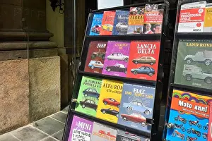 Liguria Prints: Exterior of a newsstand with Italian vintage cars magazines displayed on the sidewalk