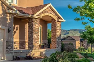 Porch Prints: Facade of home with stirs arched entrance and stone brick columns on porch