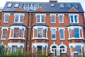 Terraced Prints: Facade of an opulent restored Victorian house in red bricks and white finishing in Clapham