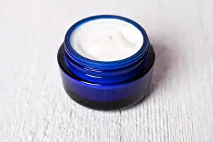 Lotion Prints: face cream in blue jar on white wooden background