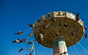 Spinning Prints: Fairground swing carousel thrill ride spinning fast against clear blue sky