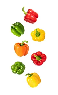 Paprika Prints: Falling peppers isolated on a white background