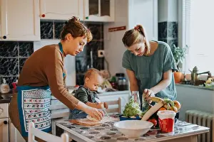 Parenting Prints: Family baking together in a warm home kitchen filled with fresh vegetables and laughter