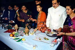 Coconuts Prints: Family Holding Diya over Red Chopdis Performing Chopda Puja During Diwali Signifying the Start of the new Financial