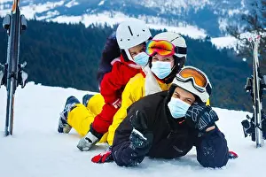 Goggles Prints: family wearing a medical mask during COVID-19 coronavirus on a snowy mountain at a ski resort