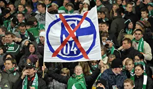 Bundesliga Prints: A fan of Bremen holds up a transparency with the crossed out logo of Schalke during the German Bundesliga match Schalke