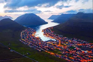 Fantastic aerial evening cityscape of Klaksvik town with glowing streets and fjord, Bordoy island, Faroe islands, Denmark. Landscape photography
