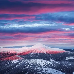 Fantastic orange winter landscape in snowy mountains glowing by sunlight. Dramatic wintry scene with snowy trees. Christmas holiday background