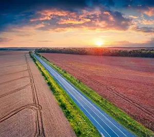 Ternopil Prints: Fantastic sunrise on Ukrainian countrysidewith asphalt road among the field of wheat