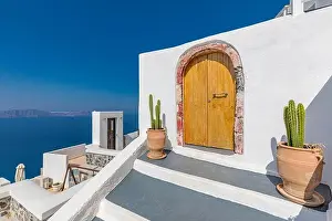 Fantastic travel background, Santorini urban landscape. Red door, gate with stairs white architecture under blue sky. Idyllic summer vacation luxury