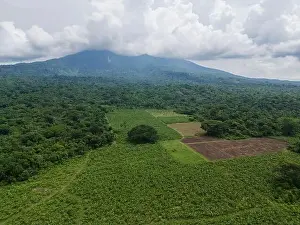 View Mountain Prints: Farm agriculture field on volcano bottom with white clouds aerial view