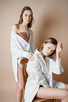 Backstage Prints: Fashion models two sisters twins beautiful nude girls looking at the camera isolated on beige background
