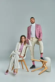 Formal Wear Prints: fashionable couple in elegant formal wear posing with armchairs on grey