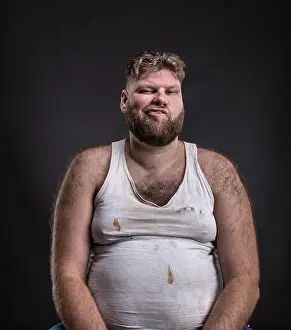 Rotting Prints: Fat unhappy man with beard in dirty shirt over dark background