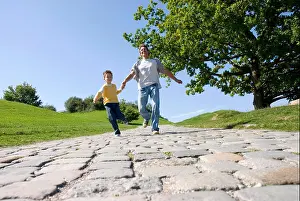 Grownup Prints: Father and son (4-7) running in park